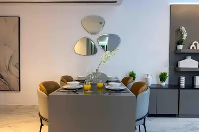a dining room with a table with chairs and mirrors at Panoramic View Dubai Mall 8 min walk Infinity pool in Dubai