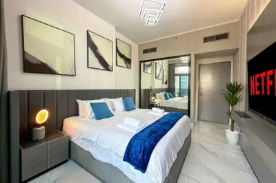 a bedroom with a large bed and a television at Panoramic View Dubai Mall 8 min walk Infinity pool in Dubai