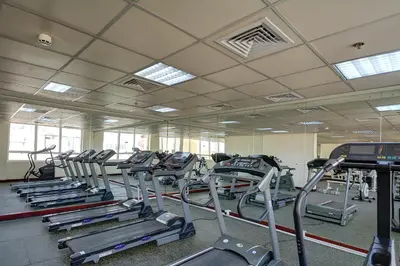 a gym with rows of tread machines in a room at Al Manar Grand Hotel Apartment in Dubai