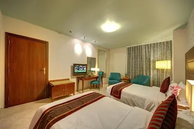 a hotel room with two beds and a desk at Al Manar Grand Hotel Apartment in Dubai