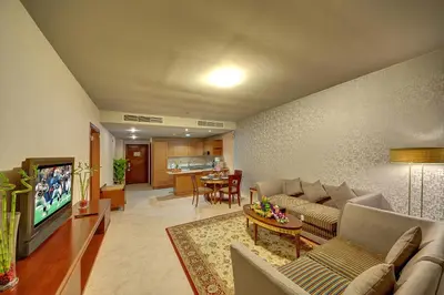 a living room with a couch and a tv at Al Manar Grand Hotel Apartment in Dubai