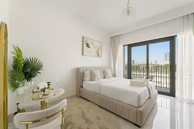 a bedroom with a bed and a table and a window at Elegant Retreat Studio in Azizi Mirage in Dubai