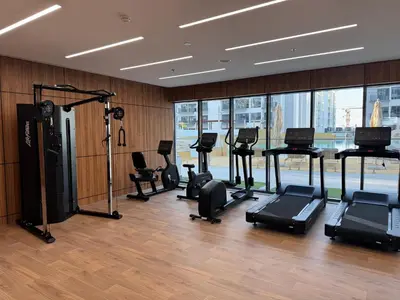 a gym with treadmills and exercise equipment in a building at Elegant Retreat Studio in Azizi Mirage in Dubai