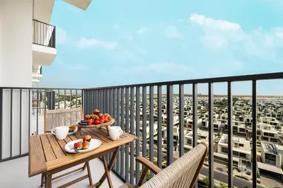 a table with a bowl of fruit on a balcony at Bright & Stylish 1BR in Park Field, Dubai Hills Estate in Dubai