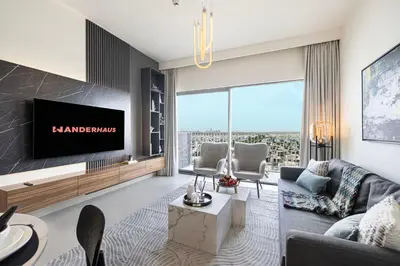 a living room with a couch and a tv at Bright & Stylish 1BR in Park Field, Dubai Hills Estate in Dubai