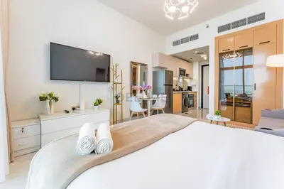 a bedroom with a large bed with a flat screen tv at High-Floor Studio with Views of Miracle Garden and Community, Near Dubai Top Attractions, Skyz by Danube, Arjan by Deluxe Holiday Homes in Dubai