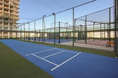 a tennis court with a net on a tennis court at High-Floor Studio with Views of Miracle Garden and Community, Near Dubai Top Attractions, Skyz by Danube, Arjan by Deluxe Holiday Homes in Dubai