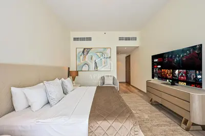 a bedroom with a large bed and a flat screen tv at Luxury Urban Living at Imperial Avenue, Downtown in Dubai