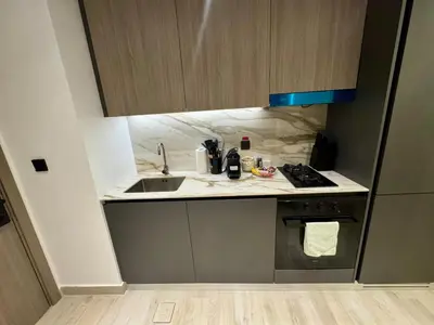 a small kitchen with a sink and a stove at Restay Homes at Oxford Gardens - Great City Escape - Swimming Pool Access in Dubai