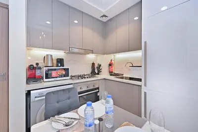 a kitchen with a table with water bottles on it at Bloomfields Cozy 1BR Azizi Riveria 47 in Dubai