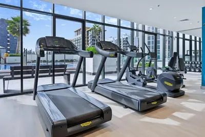 a gym with cardio equipment in a building at Bloomfields Cozy 1BR Azizi Riveria 47 in Dubai