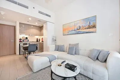 a living room with a white couch and a table at Bloomfields Cozy 1BR Azizi Riveria 47 in Dubai