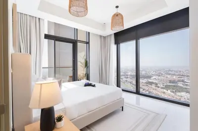 a bedroom with a white bed and a large window at StayShort - Elegant 2 BR in Business Bay with Amazing Views that sleeps 5 in Dubai
