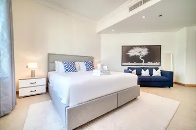 a bedroom with a large bed and a blue couch at Shoreline 14, Al Hallawi, Palm Jumeirah - Mint Stay in Dubai
