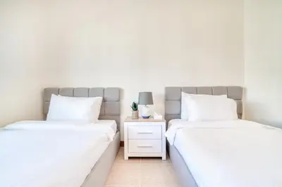 two beds in a bedroom with a nightstand between them at Shoreline 14, Al Hallawi, Palm Jumeirah - Mint Stay in Dubai