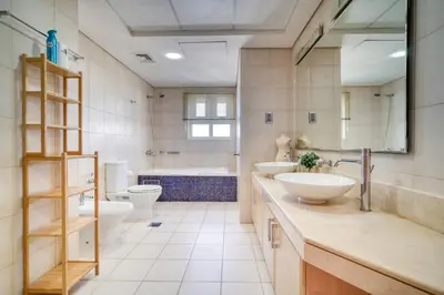 a bathroom with two sinks and a tub and two toilets at Shoreline 14, Al Hallawi, Palm Jumeirah - Mint Stay in Dubai