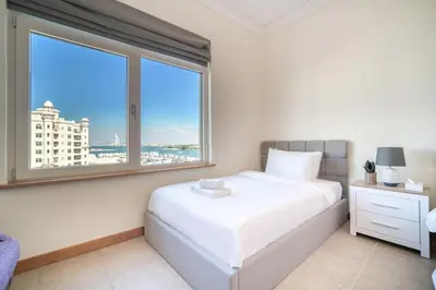 a bedroom with a bed and a large window at Shoreline 14, Al Hallawi, Palm Jumeirah - Mint Stay in Dubai