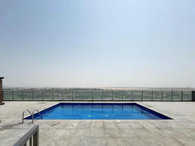 a swimming pool with a view of the beach at Elegant 1BR Apartment in Ikarus, Dubai Production City in Dubai