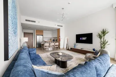 a living room with a blue couch and a table at Luxury 2BR with Burj Khalifa View in Port Rashid in Dubai