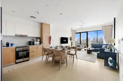 a kitchen and living room with a table and chairs at Luxury 2BR with Burj Khalifa View in Port Rashid in Dubai