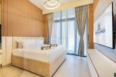 a hotel room with a bed and a flat screen tv at Modern Luxe Studio in the Heart of Meydan in Dubai