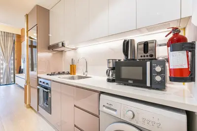 a kitchen with a sink and a microwave at Modern Luxe Studio in the Heart of Meydan in Dubai