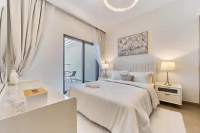 a white bedroom with a large bed and a window at Premium 3 Bedroom Townhouse in DAMAC Lagoons in Dubai