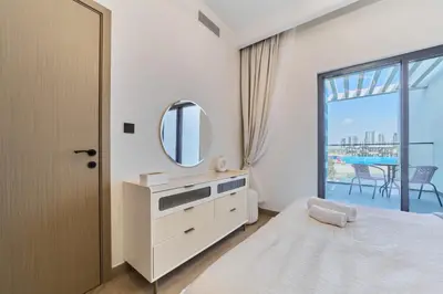 a bedroom with a bed and a mirror and a window at Premium 3 Bedroom Townhouse in DAMAC Lagoons in Dubai