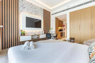 a hotel room with a large bed and a television at Open layout Studio with Balcony - Azizi Riviera 67, Al Merkadh by Deluxe Holiday Homes in Dubai