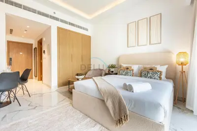 a bedroom with a large bed and a living room at Open layout Studio with Balcony - Azizi Riviera 67, Al Merkadh by Deluxe Holiday Homes in Dubai