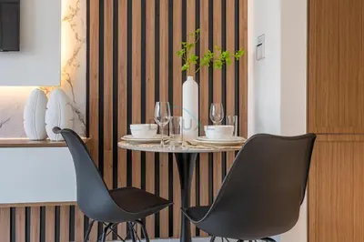 a table with two chairs and a table with glasses at Open layout Studio with Balcony - Azizi Riviera 67, Al Merkadh by Deluxe Holiday Homes in Dubai