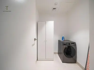 a washing machine in a room with a white wall at Luxury Loft 1 Bedroom La Voile - Building 1 Jumeirah 1 in Dubai