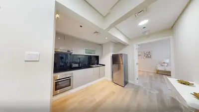 a large kitchen with stainless steel appliances and a table at Modern 2-Bedroom Apartment with JBR and Marina view on High floor in Dubai
