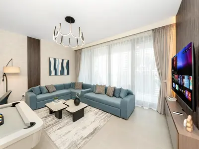 a living room with blue couches and a flat screen tv at Royal Vista25 - 4BR with Billiard Table at Forte Tower Downtown Dubai in Dubai