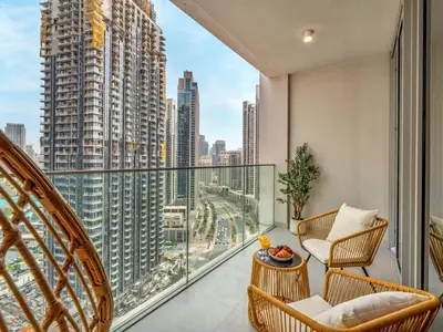 a balcony with chairs and a view of a city at Royal Vista25 - 4BR with Billiard Table at Forte Tower Downtown Dubai in Dubai