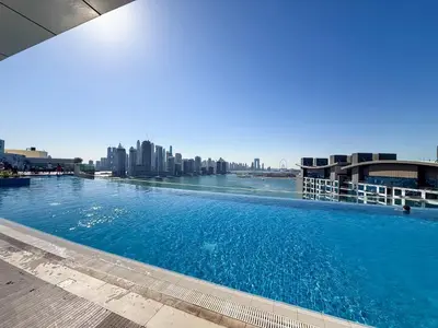 a large swimming pool with a city in the background at PVH - Seven Palm - Modern Studio with Beach Access near Palm Jumeirah Mall in Dubai