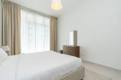 a white bedroom with a bed and a window at CitiHome - Spacious 2BR - Park Gate Residences in Dubai