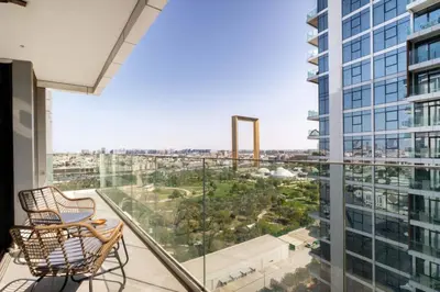 a balcony with two chairs and a view of a city at CitiHome - Spacious 2BR - Park Gate Residences in Dubai