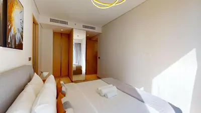 a white room with a bed and a couch at Vacationer l Vida T2 1 Bedroom l Direct Access to Dubai Mall in Dubai