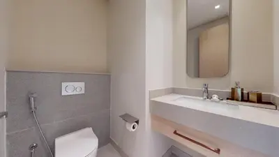 a bathroom with a sink and a toilet and a mirror at Vacationer l Vida T2 1 Bedroom l Direct Access to Dubai Mall in Dubai