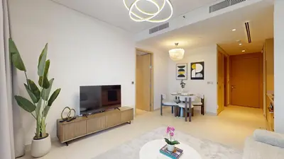 a living room with a television and a table at Vacationer l Vida T2 1 Bedroom l Direct Access to Dubai Mall in Dubai