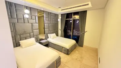 a hotel room with two beds and a window at Beachfront comfort your private escape at Palm jumeriah th8 residences in Dubai
