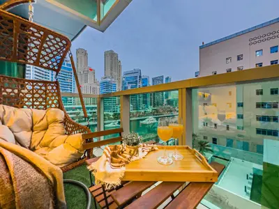 a balcony with a table and a chair on a building at Marina Elegance, Walk to JBR Beach and Ain Dubai w Stunning Canal View in Dubai