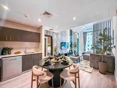 a kitchen and living room with a table and chairs at Marina Elegance, Walk to JBR Beach and Ain Dubai w Stunning Canal View in Dubai