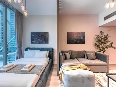 a living room with two beds and a couch at Marina Elegance, Walk to JBR Beach and Ain Dubai w Stunning Canal View in Dubai