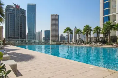 a large swimming pool in a city with tall buildings at Frank Porter - Damac Maison Prive in Dubai