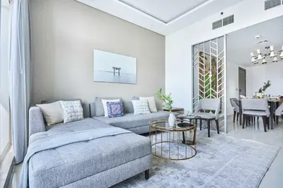 a living room with a couch and a table at Frank Porter - Damac Maison Prive in Dubai