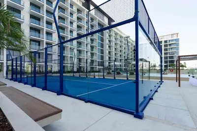 a tennis court in front of a building at Binghatti Phoenix Luxe 1BR with Tranquil Pool View in Dubai