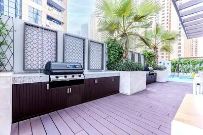 a outdoor kitchen with a grill on a balcony at Stylish 2 Bed with full marina view on high floor in Dubai