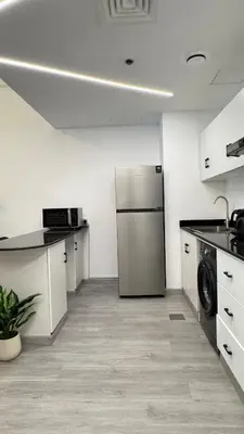 a kitchen with a stainless steel refrigerator in a room at 1BDR Large Living Room Nearby Metro in Dubai